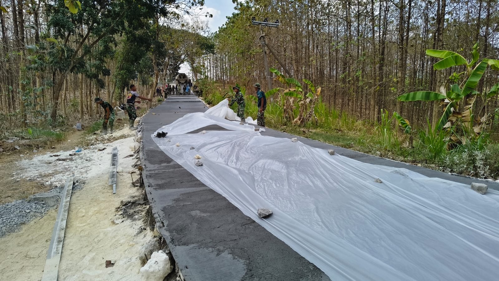 Perkuat Infrastruktur, Satgas TMMD 129 Kodim 0812/Lamongan Gunakan Plastik untuk Lindungi Hasil Cor Jalan